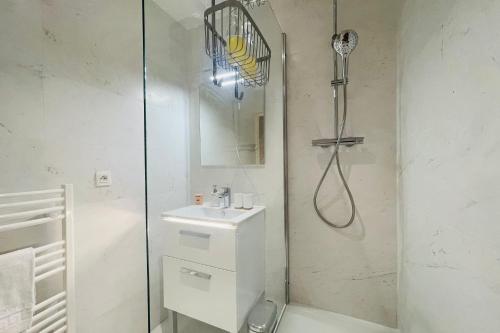 a white bathroom with a shower and a sink at Splendid apartment at the foot of the castle of Amboise - View of the Loir in Amboise