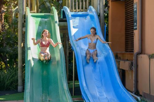 a man and a woman riding down a water slide at San Lameer Villa 2026 - One bedroom Classic - 2 pax - San Lameer Rental Agency in Southbroom