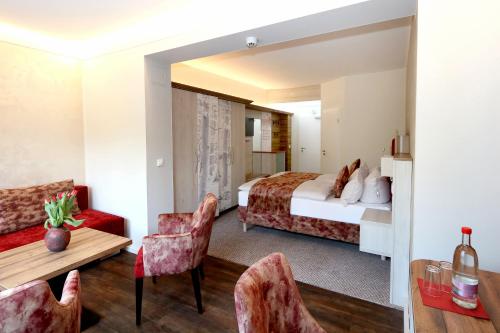 a hotel room with a bed and a table and chairs at Waldhotel Ehrental in Schmalkalden