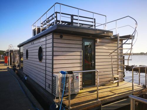 a small house on a dock on the water at Ostsee Hausboot Schleswig Ostseeblick 1 in Schleswig