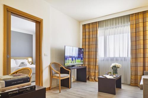 a hotel room with a television and a mirror at Living Place Hotel in Villanova