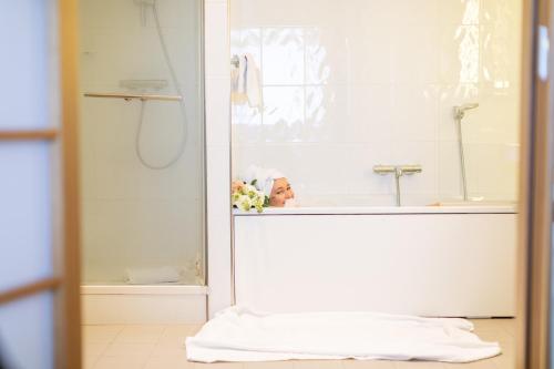 a woman sitting in a bath tub in a bathroom at Living Place Hotel in Villanova