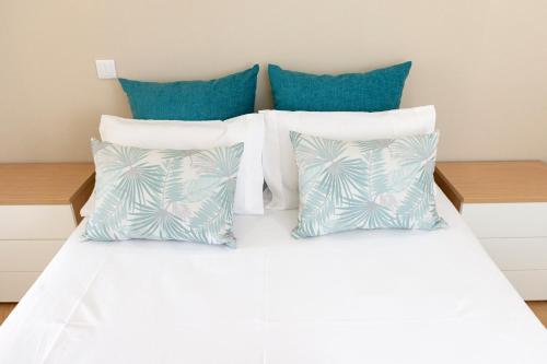 Una cama blanca con almohadas azules. en The Modern 1385 Apartment, en Batalha