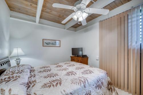 a bedroom with a ceiling fan and a bed at Kona Bali Kai #374 in Kailua-Kona