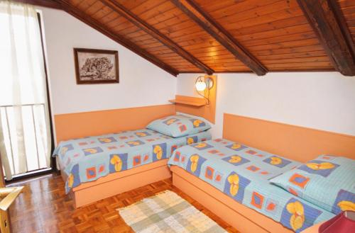 um quarto com 2 camas e uma janela em Apartments with a parking space Kornic, Krk - 416 em Kornić