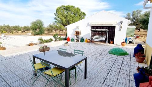 a table and chairs on a patio with a building at Monte dos Abrunhos in Vimieiro