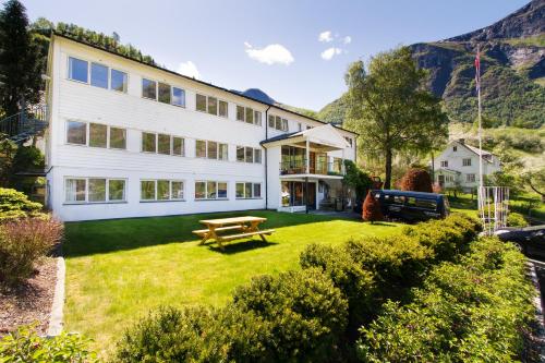 a large white building with a picnic table in the yard at Heimly Pensjonat in Flåm