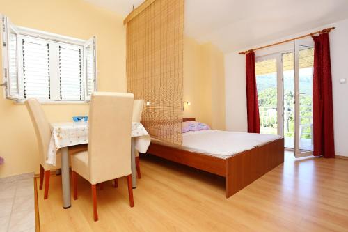 a bedroom with a table and a bed and a table and chairs at Apartments with a parking space Zuljana, Peljesac - 254 in Žuljana