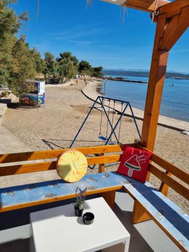a bench with a umbrella on a beach at Family friendly seaside apartments Nevidjane, Pasman - 325 in Neviđane