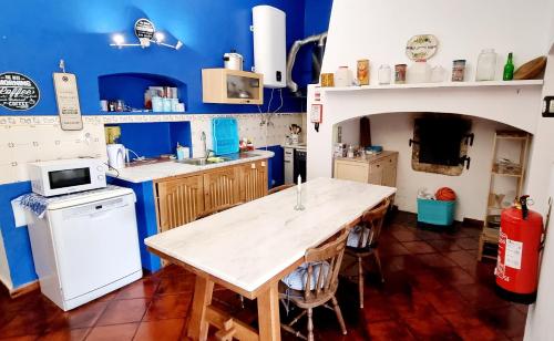 a kitchen with blue walls and a wooden table at Monte dos Abrunhos in Vimieiro