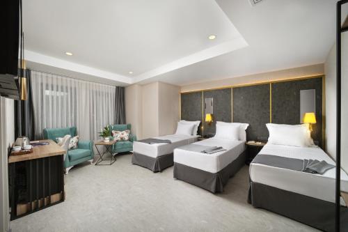 a hotel room with two beds and a couch at Imagine Istanbul in Istanbul