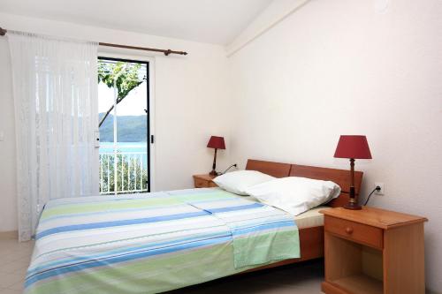a bedroom with a bed and a large window at Seaside apartments with a swimming pool Viganj, Peljesac - 260 in Viganj