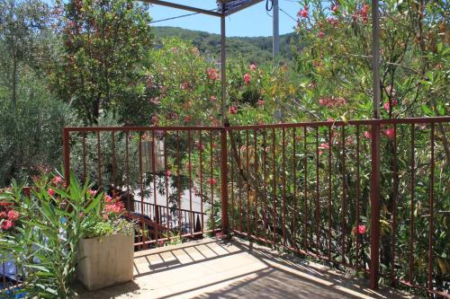 a metal fence with pink flowers in a garden at Apartments by the sea Valun, Cres - 386 in Valun