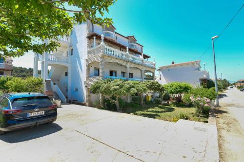 a car parked in front of a white building at Apartments and rooms by the sea Tkon, Pasman - 336 in Tkon