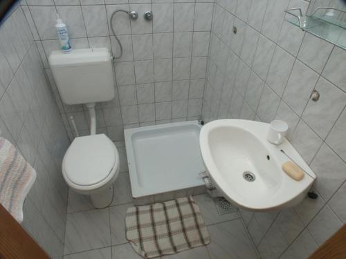 une salle de bain blanche avec toilettes et lavabo dans l'établissement Secluded fisherman's cottage Krknata, Dugi otok - 399, à Žman