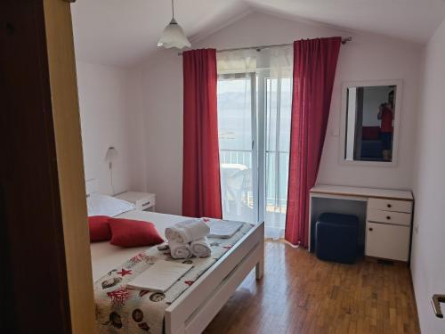 a bedroom with a bed and a window with red curtains at Apartments and rooms by the sea Trpanj, Peljesac - 258 in Trpanj