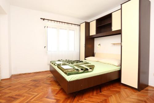 a bedroom with a bed with a stove in it at Apartments and rooms by the sea Trpanj, Peljesac - 258 in Trpanj
