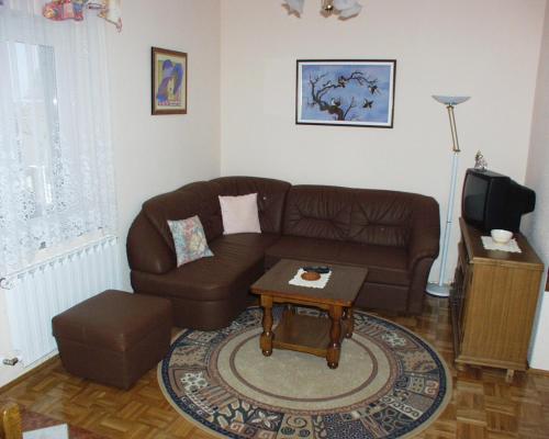 a living room with a brown couch and a table at Family-friendly apartments with swimming pool Kraj, Pasman - 334 in Kraj