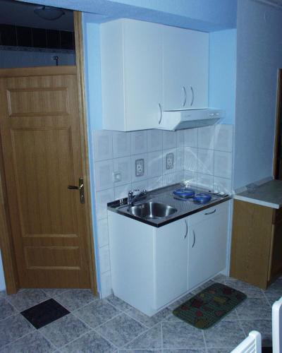 a small kitchen with a sink and a door at Family-friendly apartments with swimming pool Kraj, Pasman - 334 in Kraj