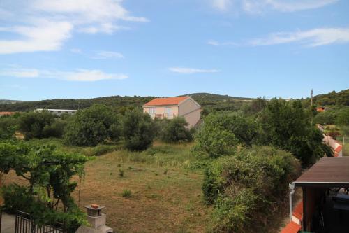 a view of a yard with a house in the background at Family-friendly apartments with swimming pool Kraj, Pasman - 334 in Kraj