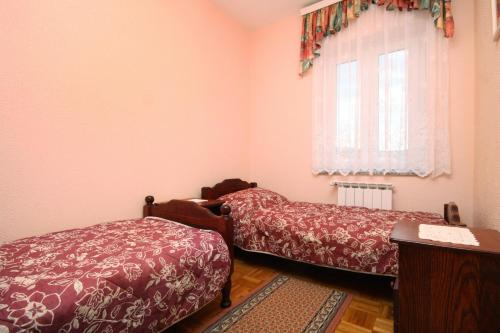 a bedroom with two beds and a window at Family-friendly apartments with swimming pool Kraj, Pasman - 334 in Kraj