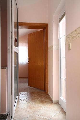 a hallway with a wooden door and a window at Family-friendly apartments with swimming pool Kraj, Pasman - 334 in Kraj
