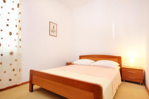 Schlafzimmer mit einem Bett mit weißer Bettwäsche und einem Nachttisch in der Unterkunft Apartments by the sea Orebic, Peljesac - 251 in Orebić