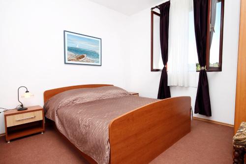 1 dormitorio con cama, mesa y ventanas en Family friendly seaside apartments Zaton, Zadar - 298, en Zaton