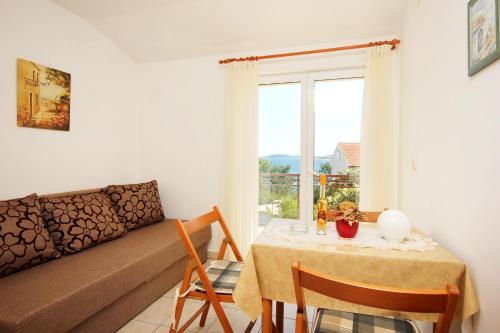 ein Wohnzimmer mit einem Tisch und einem Sofa in der Unterkunft Apartments by the sea Orebic, Peljesac - 275 in Orebić