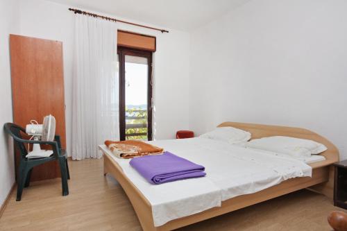 um quarto com uma cama, uma cadeira e uma janela em Apartments by the sea Sveti Petar, Biograd - 358 em Sveti Petar