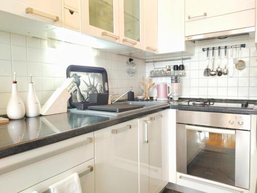 a kitchen with white cabinets and a sink at Fountain View Apartment in Zagreb