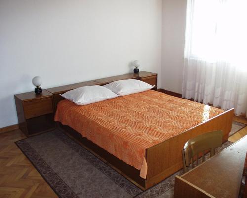 a bedroom with a large bed with two pillows at Apartments by the sea Podgora, Makarska - 316 in Podgora