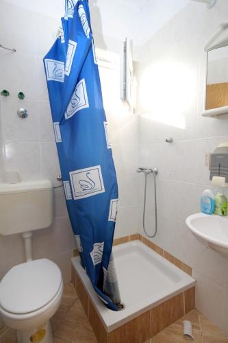 a bathroom with a toilet and a shower curtain at Apartments by the sea Mrljane, Pasman - 319 in Neviđane