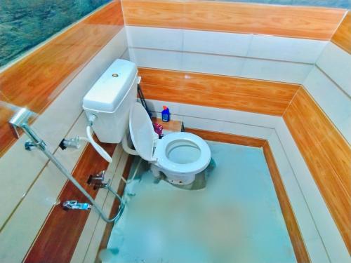 a small bathroom with a toilet in a boat at The Gangotri Homestay By Preet rS in Barkot