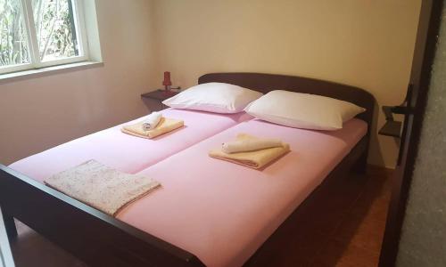 a bed with two towels and two pillows on it at Apartment Valun 386a in Valun
