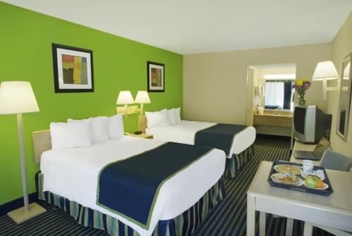 two beds in a hotel room with green walls at Days Inn by Wyndham Richmond Hill/Savannah in Richmond Hill