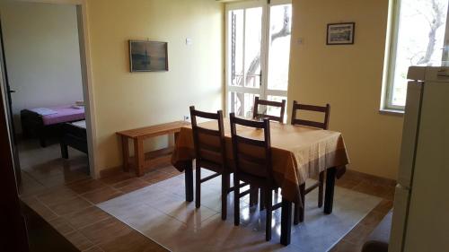 a dining room with a table and chairs and a window at Apartment Valun 386a in Valun