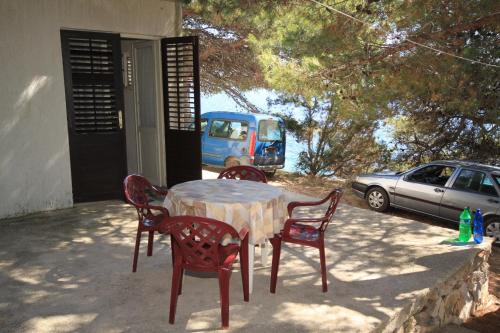 una mesa y sillas en un patio con coche en Secluded fisherman's cottage Cove Ripisce, Dugi otok - 394 en Brbinj