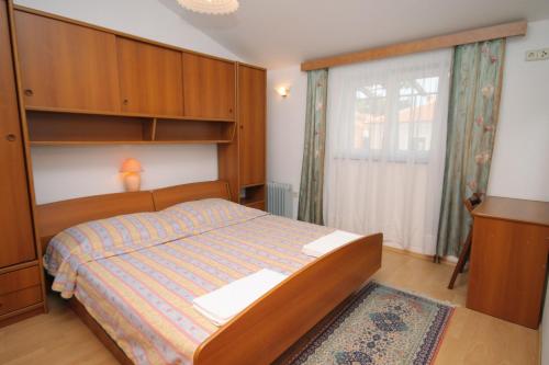 - une petite chambre avec un lit et une fenêtre dans l'établissement Apartments and rooms with parking space Njivice, Krk - 408, à Njivice