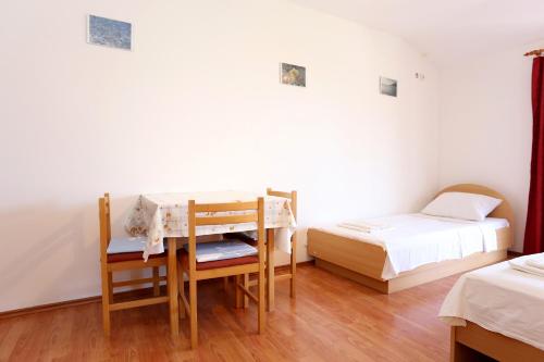 Cette chambre comprend deux lits, une table et des chaises. dans l'établissement Studio Zuljana 254a, à Žuljana