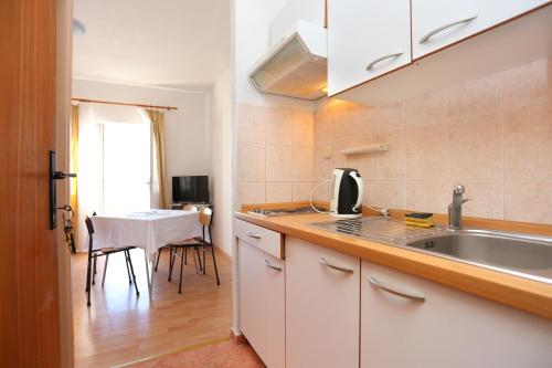 cocina con fregadero y mesa en una habitación en Apartment Igrane 311b, en Igrane