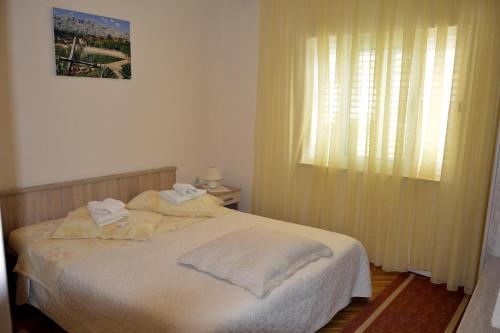 a bedroom with a bed with white sheets and a window at Apartments by the sea Orebic, Peljesac - 269 in Orebić