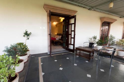 a room with potted plants and an open door at Hanuwant Niwas Jodhpur in Jodhpur