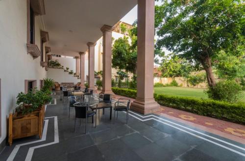 a patio with tables and chairs in a building at Hanuwant Niwas Jodhpur in Jodhpur