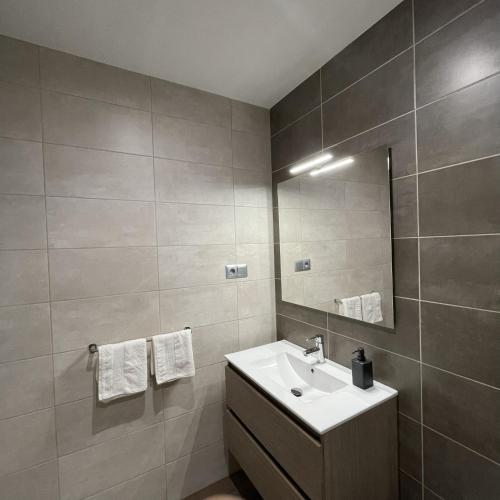 a bathroom with a sink and a mirror at Apartamentos Toffe in Outes