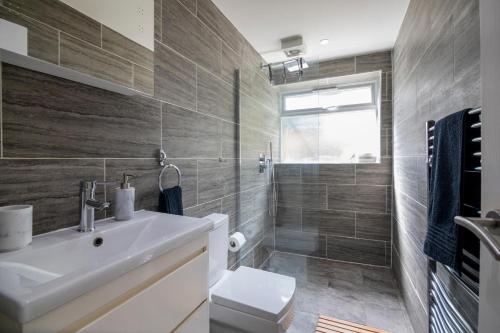 a bathroom with a sink and a toilet and a shower at Gorgeous Modern Apartment near Redhill Station inc Private Garden & Parking in Redhill