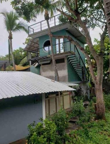 a building with a balcony and stairs on it at Lote 44 Guesthouse in El Zonte