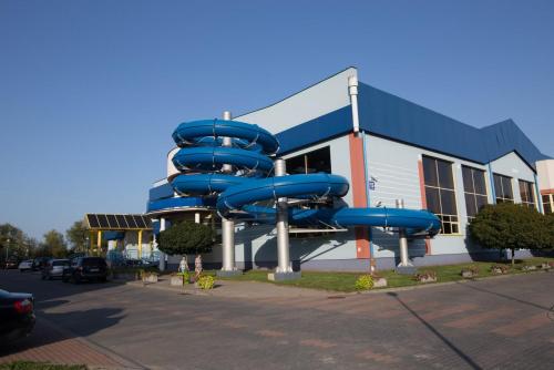 a blue water slide in front of a building at Domek w Sajenku in Augustów