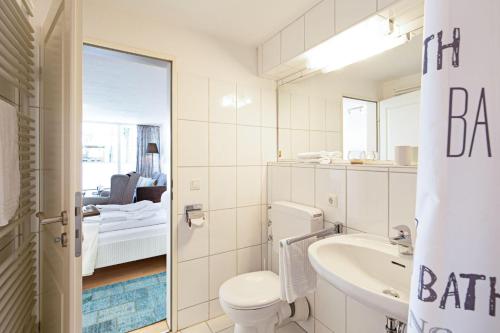 een badkamer met een toilet, een wastafel en een spiegel bij Solskin in List