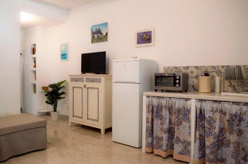 una cucina con frigorifero e forno a microonde di Casa Vacanze L'essenziale a Martina Franca